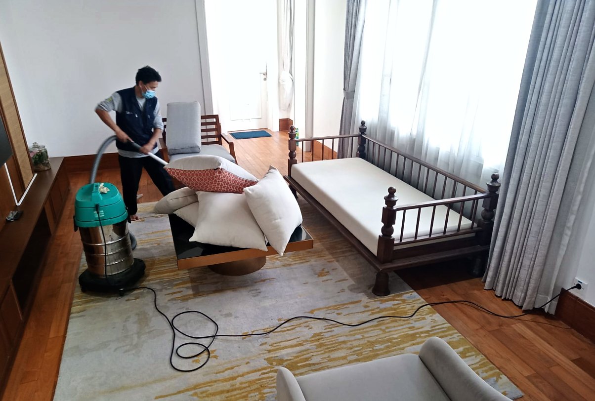 Petugas IndoCareService memvakum puff dan bangku jok di kamar tidur