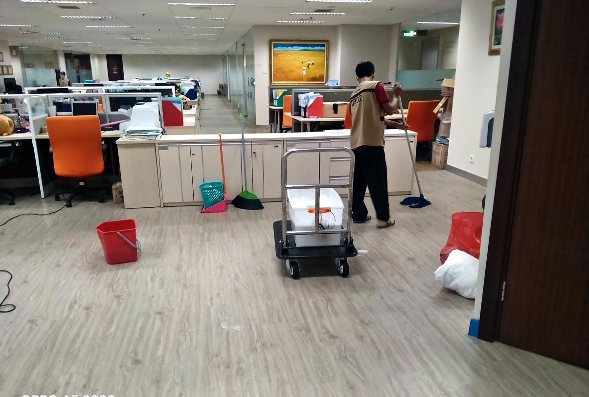 Tim IndoCareService membersihkan lantai dan area kantor