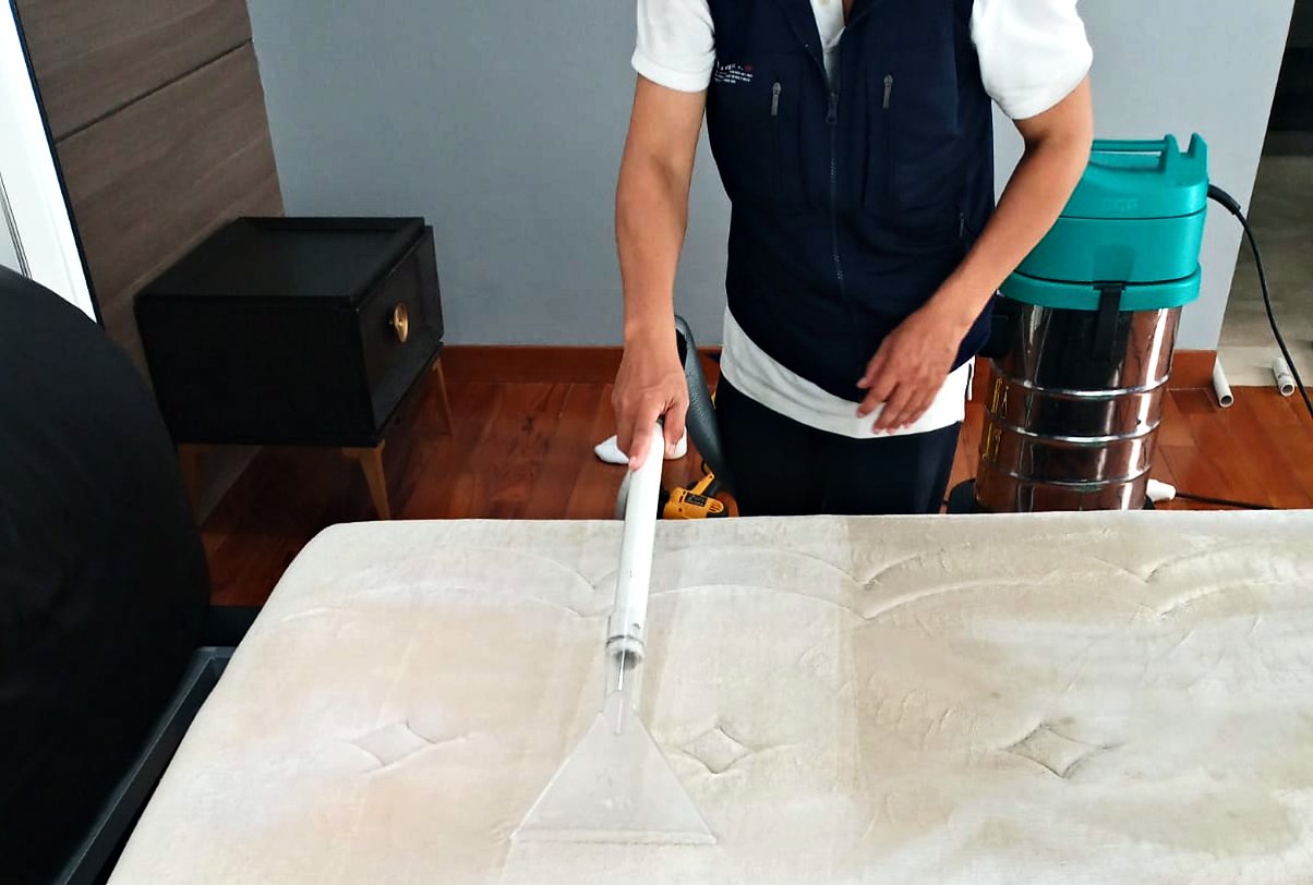Petugas IndoCareService mencuci spring bed dengan mesin ekstraksi