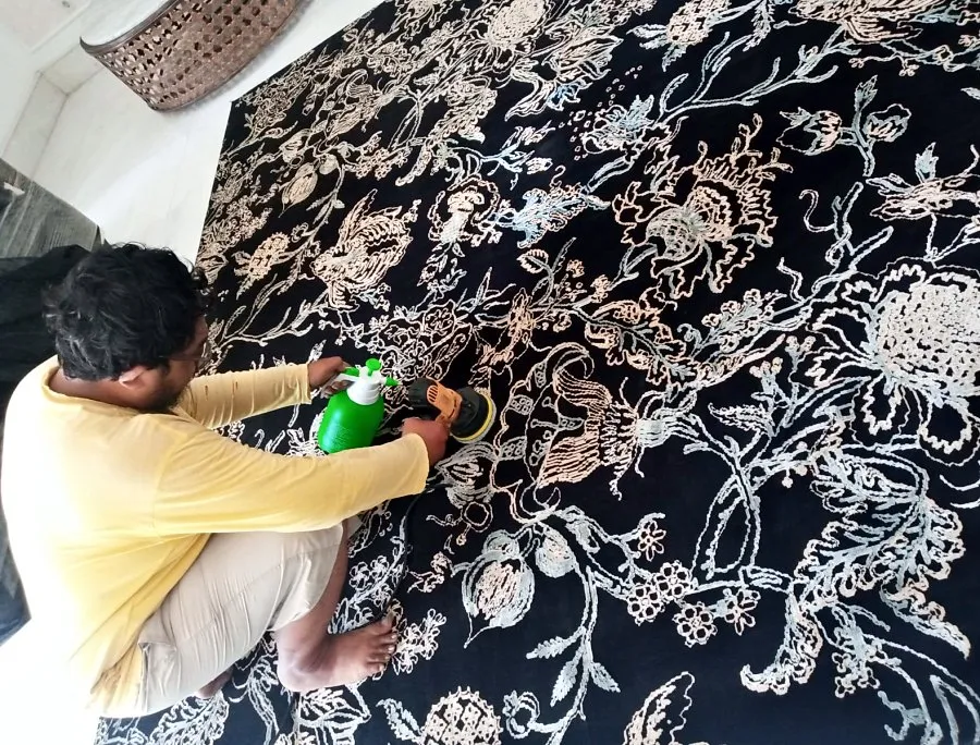 Pekerja mencuci permadani motif bunga