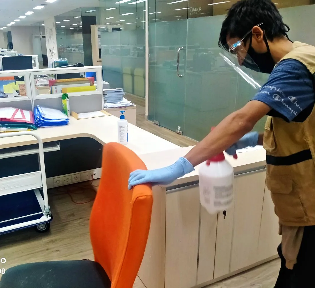 Petugas IndoCareService membersihkan kursi kantor